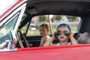 Kids driving in the front seat with shades