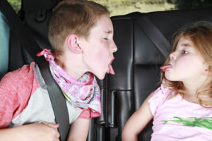 brother and sister sticking out tongues